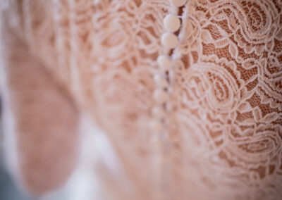 Détail de dentelle et boutons sur robe de mariée sur mesure